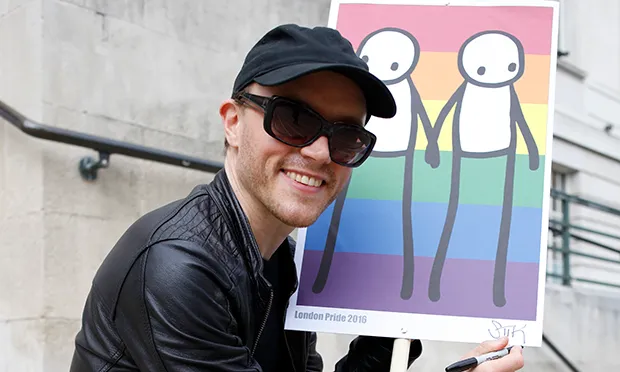 Stik outside Hackney Town Hall with a smaller version of Hackney Pride, on which Holding Hands is based