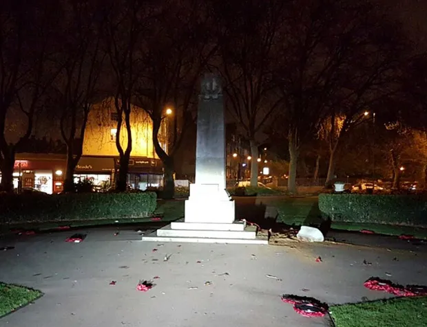 One of the photographs tweeted by Hackney MPS showing wreaths scattered on the ground around the memorial