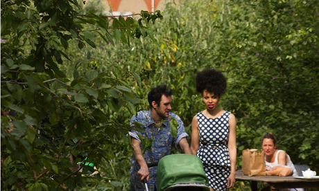 A young couple stroll through Dalston Eastern Curve Garden