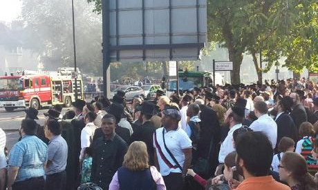 Crowds gather as building burns in Stamford Hill. Photograph: Chaim Hochhauser